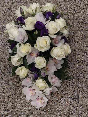 Vaaleista ja violeteista kukista sidottu hautavihko